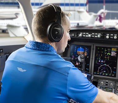 Pilot with a Bose headset on in cockpit